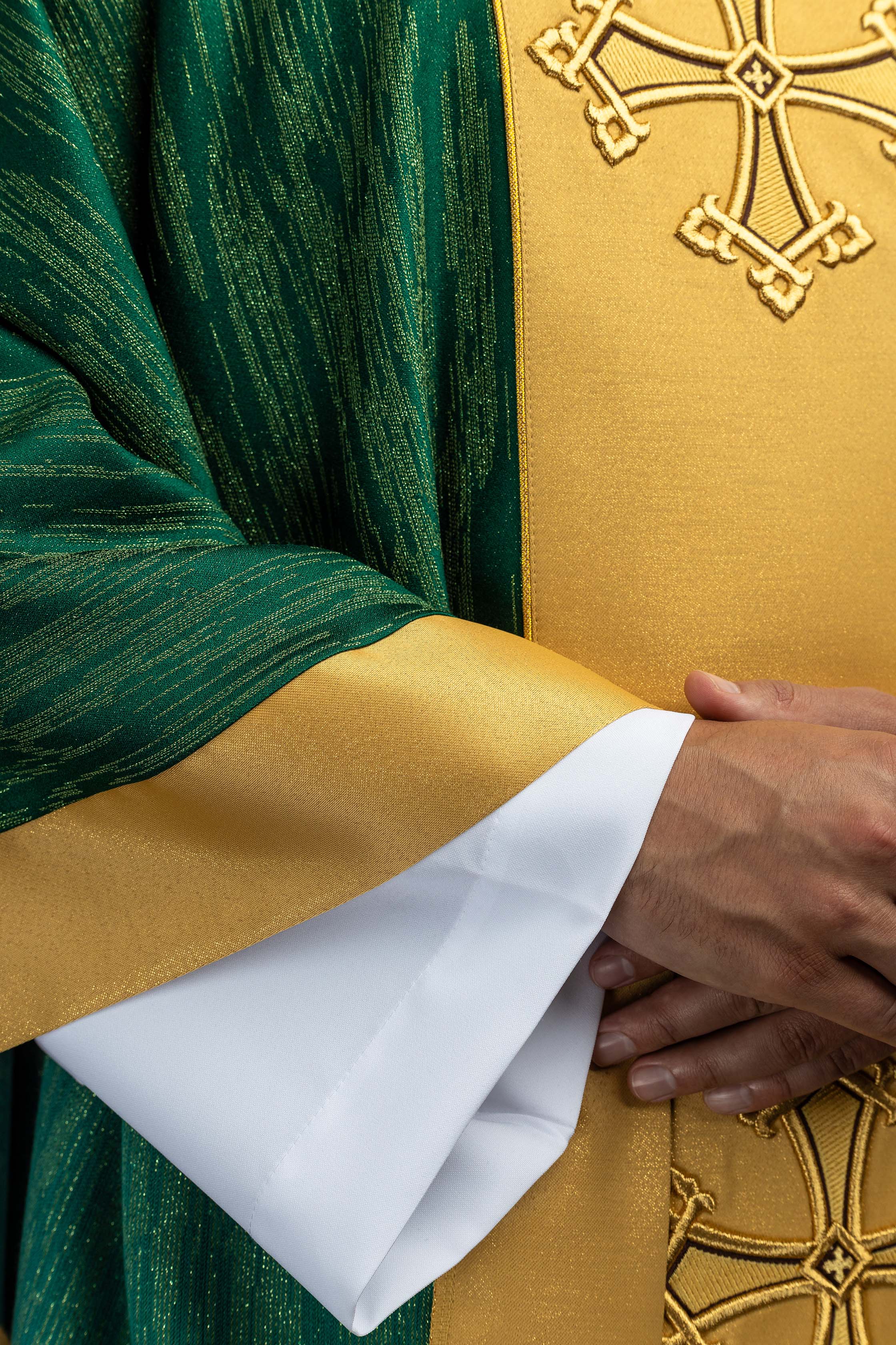 Zeleni misnica s izvezenim motivom križa s pojasom na ukrasnoj tkanini